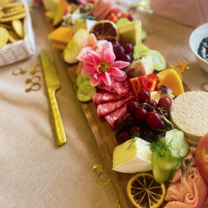 Event Catering Grazing Board setup with meats, cheeses, flowers, fruits, crackers and jams by Pachamama Catering
